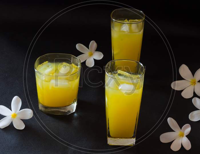 Three glasses of fresh orange juice with ice,isolated on black background.