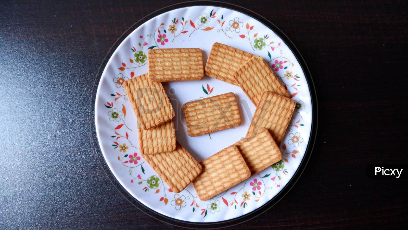 Glucose Biscuits Served in white printed plate with black background