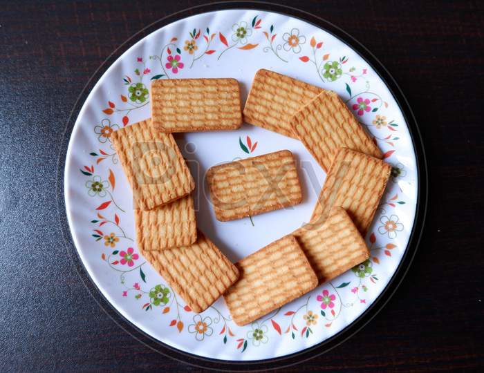 Glucose Biscuits Served in white printed plate with black background