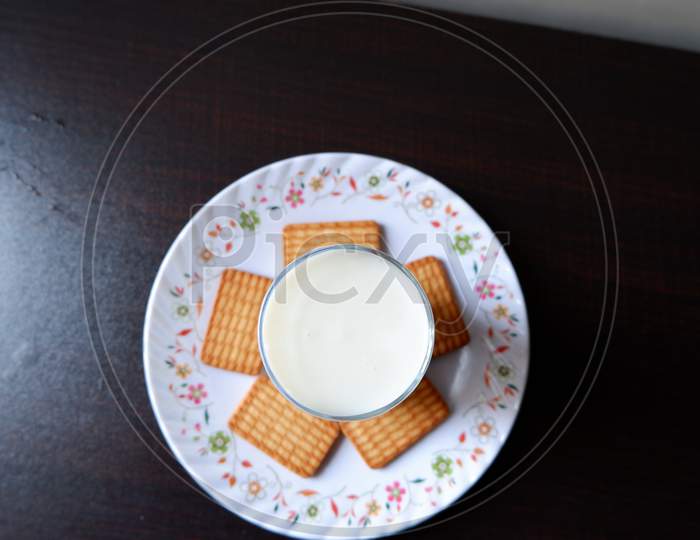 Top View of Milk in a glass with few biscuits on a plate