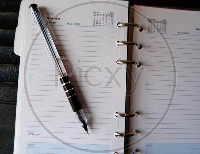 Top view of open pen placed on open diary