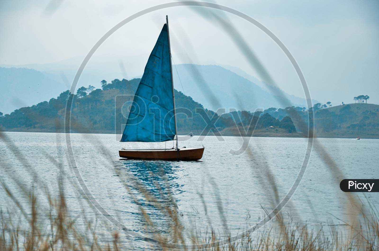 Image of Sailing yacht boat in the foggy sea against mountains
