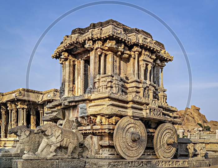 Richly Sculpted Stone Chariot With Clear Blue Sky Background In Hampi, Karnataka.