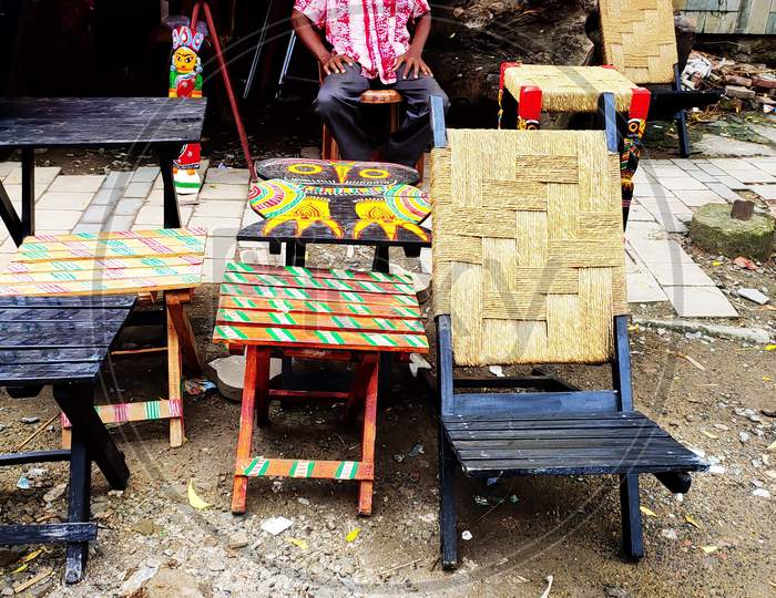 A street vendor sales colorful wooden furnitures on the street in Kolkata, India. Focus on subjects.