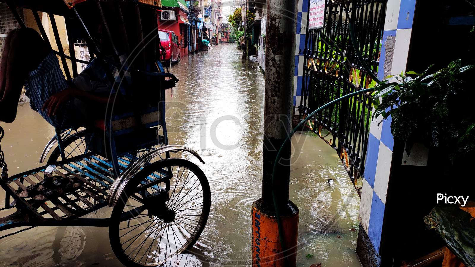 A man pulled rickshaw stands on the stage water after heavy rainfall in Kolkata, India.