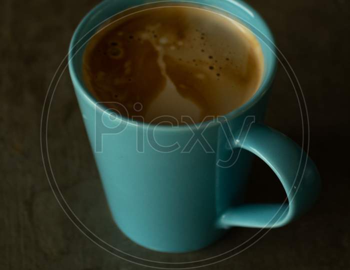 Light Blue Mug On A Concrete Table Containing An Espresso Coffee.