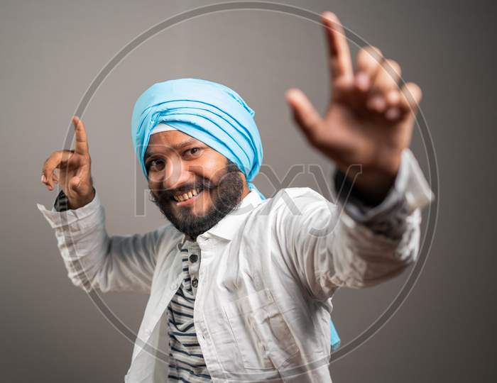 Young Sikh Man Balle Balle Gurmukhi Style Indian Cultural Dancing On Studio Background - Concept Of Happiness And Relaxation