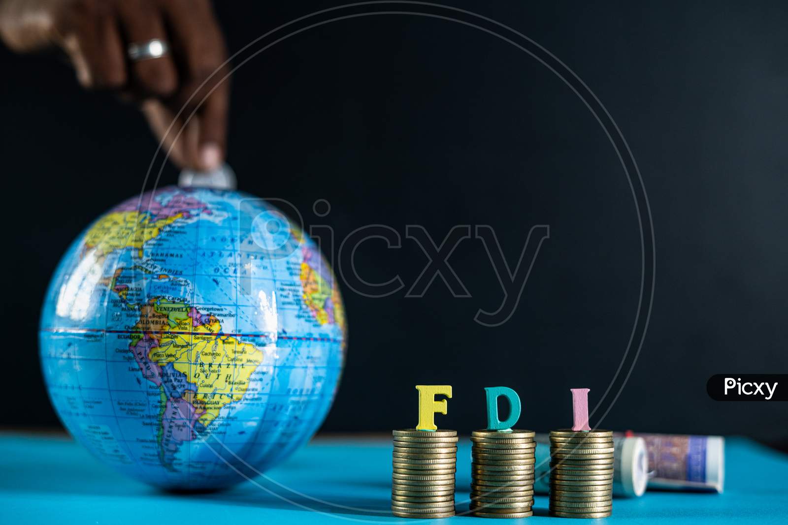 Focus On Fdi Letters On Coins, Concept Of Fdi Or Foreign Direct Investment, Showing By Placing Coins Inside The Globe From Behind.