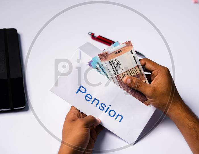 Shoulder Shot Of Man Opening Received Pension Money From Envelope - Concept Of Retirement Pension Payments And Savings.