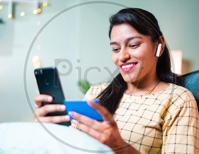 Happy Smiling Young Woman Buying Or Ordering Online Using Mobile And Credit Card - Concept Of E-Commerce Shopping, Virtual Or E-Payment And Shopaholic Lifestyle.