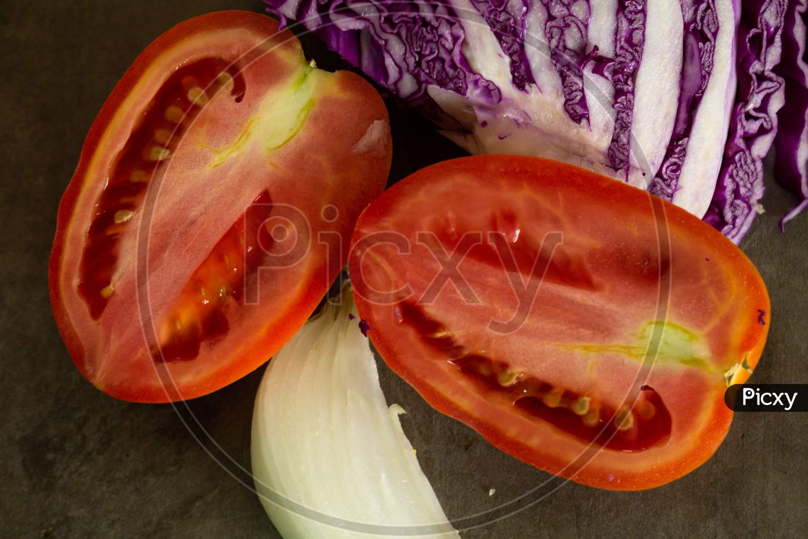 Tomatoes And Red Cabbage Cut On A Table. Ingredients For A Vegan Salad.