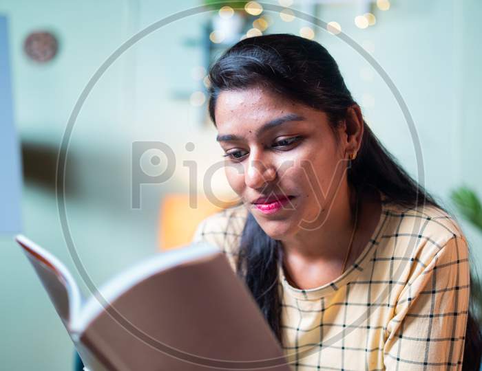 Medium Shot Of Concentrated Young Girl Reading Book - Concept Of Leisure Activities, Preparing For Exam, Education And Learning