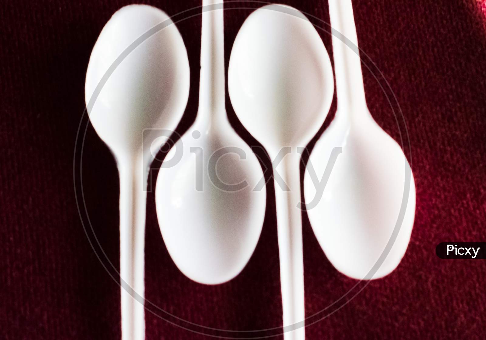 Some Empty Plastic Spoon In A Red Carpet