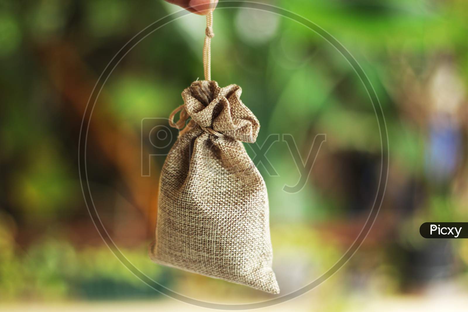 A View Of A Money Bag Stock Photo In Bokesh Background
