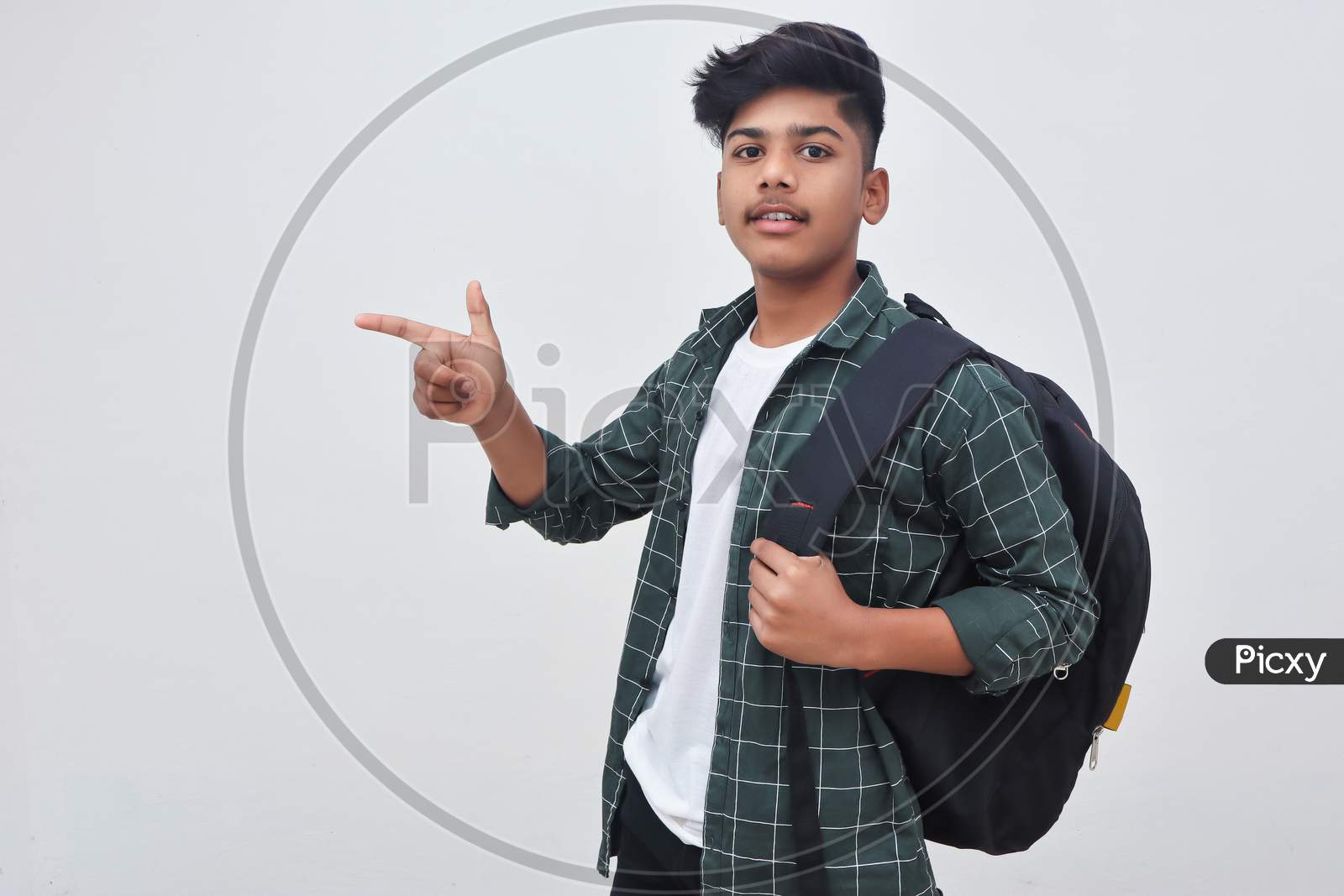 Handsome Indian College Boy Pointing With Hand On White Background.