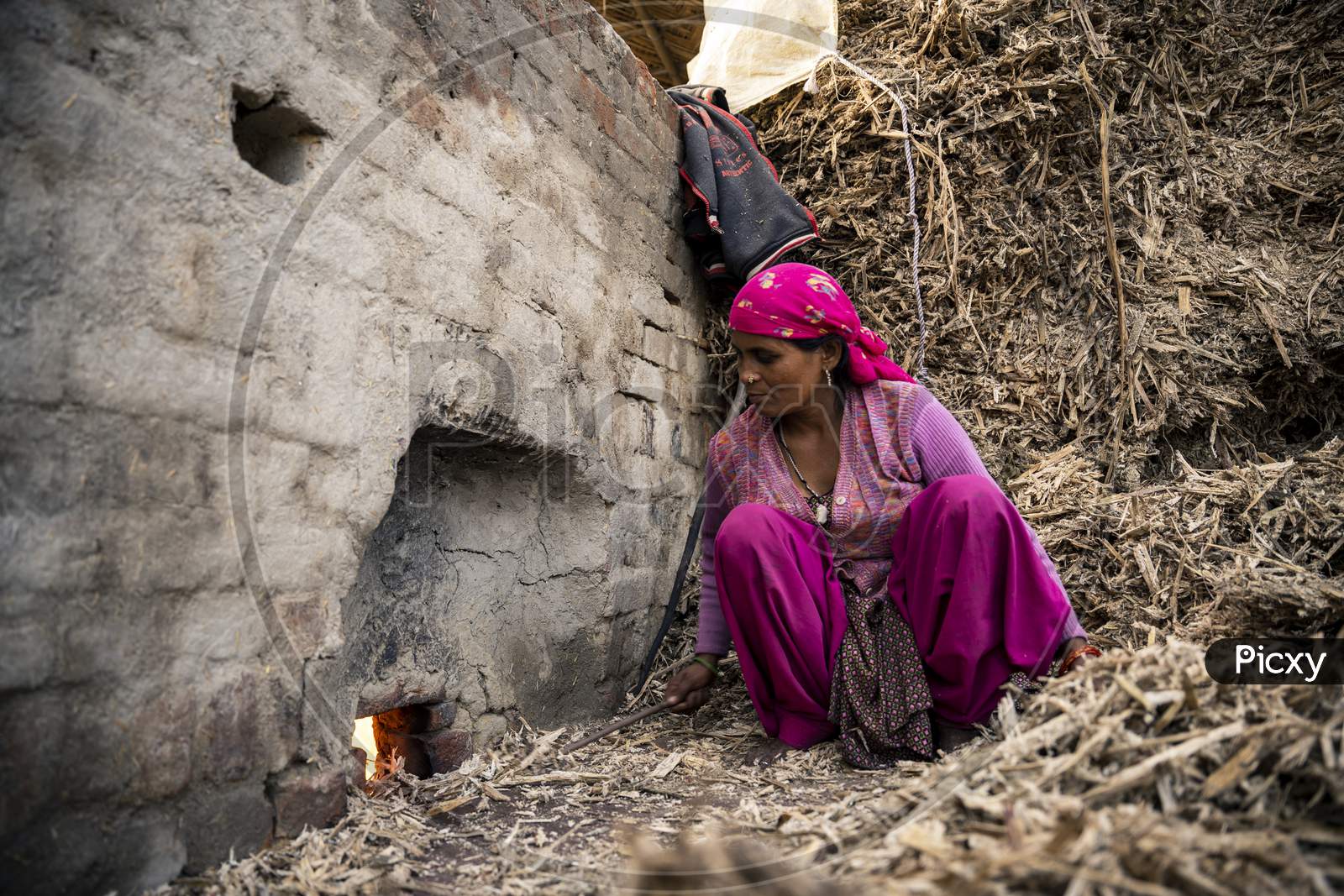 Moradabad, Uttar Pradesh- January 12 2022- A Village Woman Working In The Jaggery Making Factory. Woman Working With Waste Sugarcane.