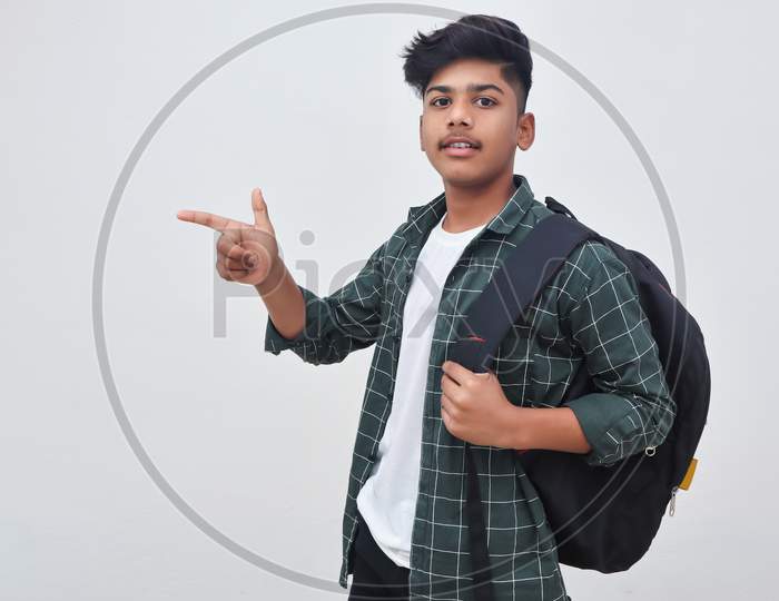 Handsome Indian College Boy Pointing With Hand On White Background.