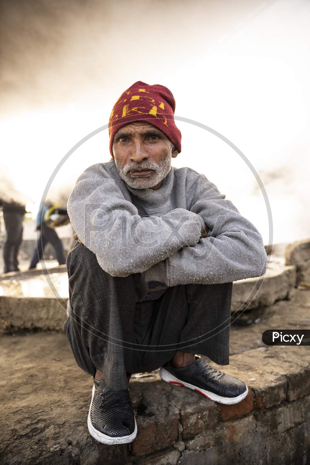 Moradabad, Uttar Pradesh- January 12 2022- Portrait Of An Old Aged Man From Village Sitting On A Stone Pedestal.