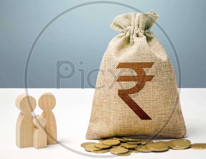 Indian Rupee Money Bag With Money And Family Figurines. Financial Support For Social Institutions. Providing Assistance To Citizens. Investments In Human Capital, Culture And Social Projects.