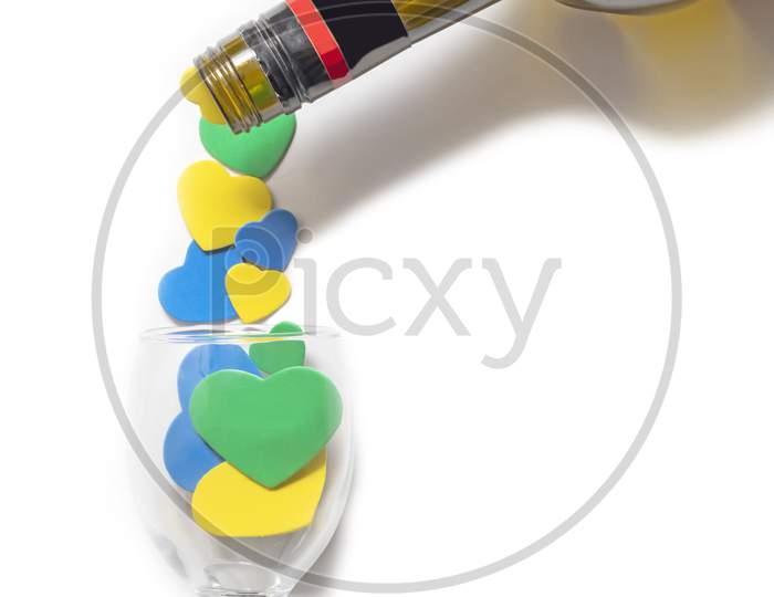 Valentine'S Day Backgrounds. Multi-Colored Hearts Are Poured Into A Glass From A Bottle. Isolated On White