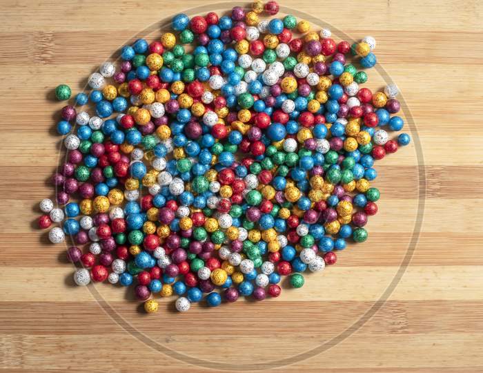 Multi-Colored Small Thermocol Decorative Balls On A Wooden Table