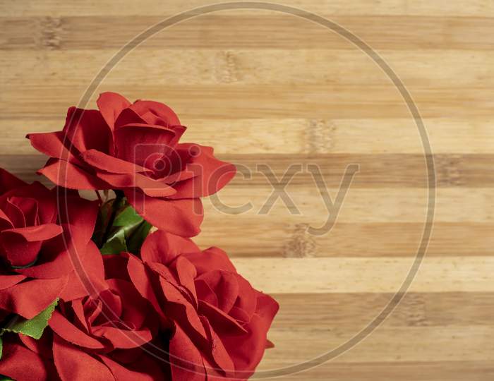 Bouquet Of Red Roses On A Wooden Table