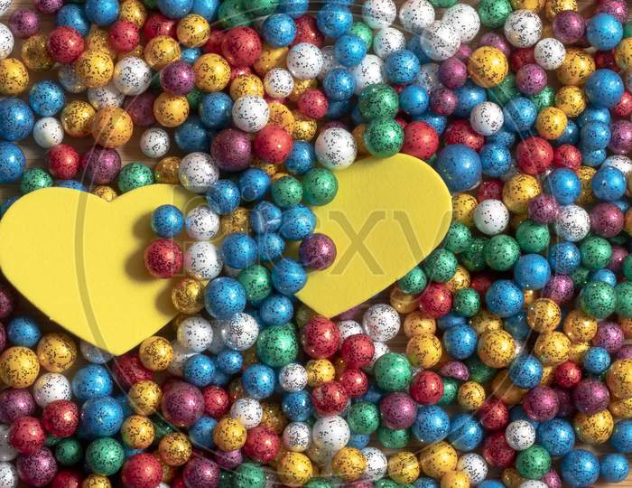 Valentine'S Day Background. Multicolor Small Size Thermocol Decorative Balls With Two Yellow Hearts On Top