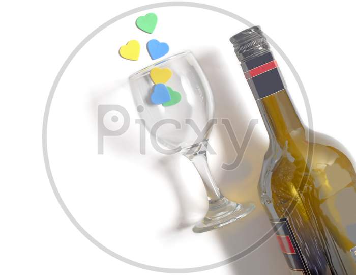 Champagne Bottle And Multi-Colored Hearts In A Glass, Isolated In White