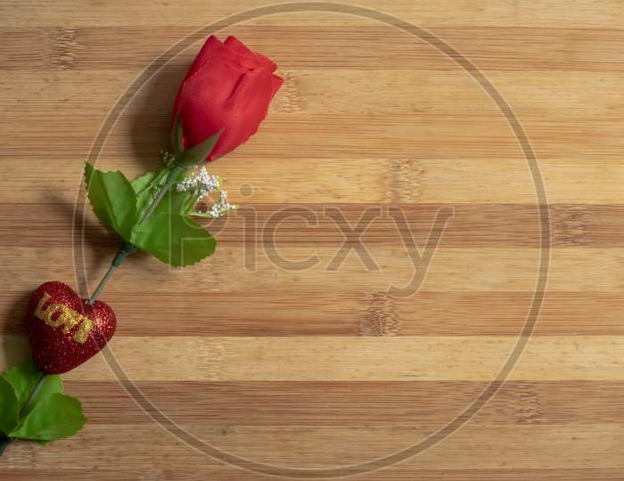 Valentine'S Day Backgrounds With A Red Plastic Roses On A Wooden Table For The Concept Of Love.