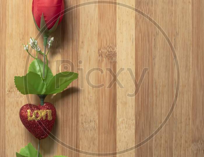 Red Roses And Little Hearts On A Wooden Table For The Concept Of Love.