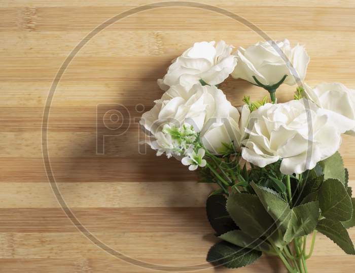 White Roses On A Wooden Table