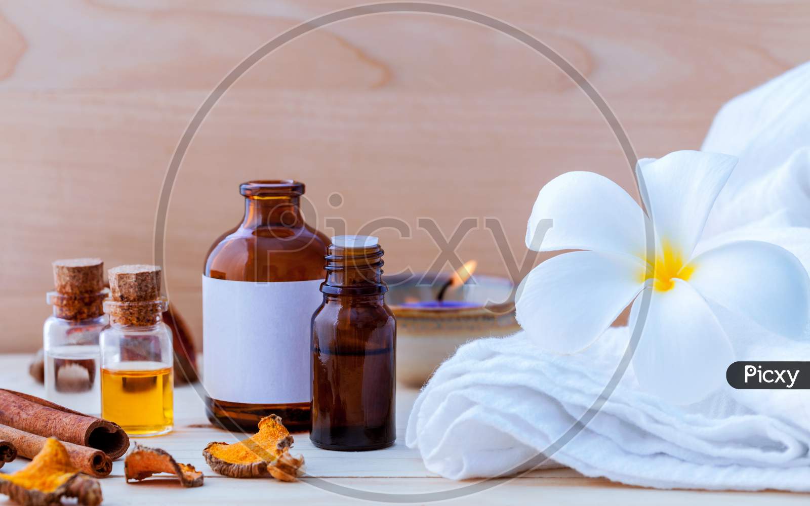 Natural Spa Ingredients And Bottle Of Herbal Extract Oil For Alternative Medicine And Aromatherapy. Thai Spa Theme With Ayurvedic Therapist On Shabby Wooden Background.