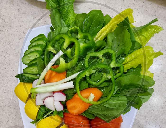Mixed  Vegetable salad with lettuce, green pepper, cucumber, carrot, tomatoes, lemon.