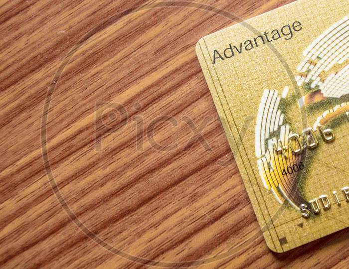 A Part Of Credit Card Lying On Wood Table Background. Online Shopping Concept.