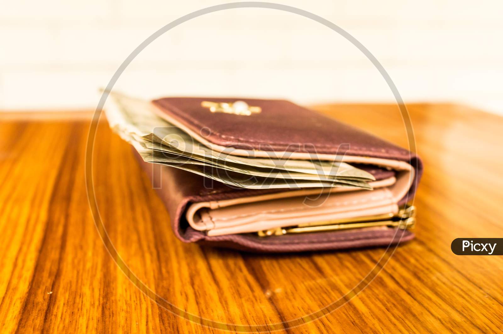 Indian Five Hundred (500) Rupee Cash Note In Brown Color Wallet Leather Purse On A Wooden Table. Business Finance Economy Concept. Side Angel View Extreme Close Up With Copy Space Room For Text Left.