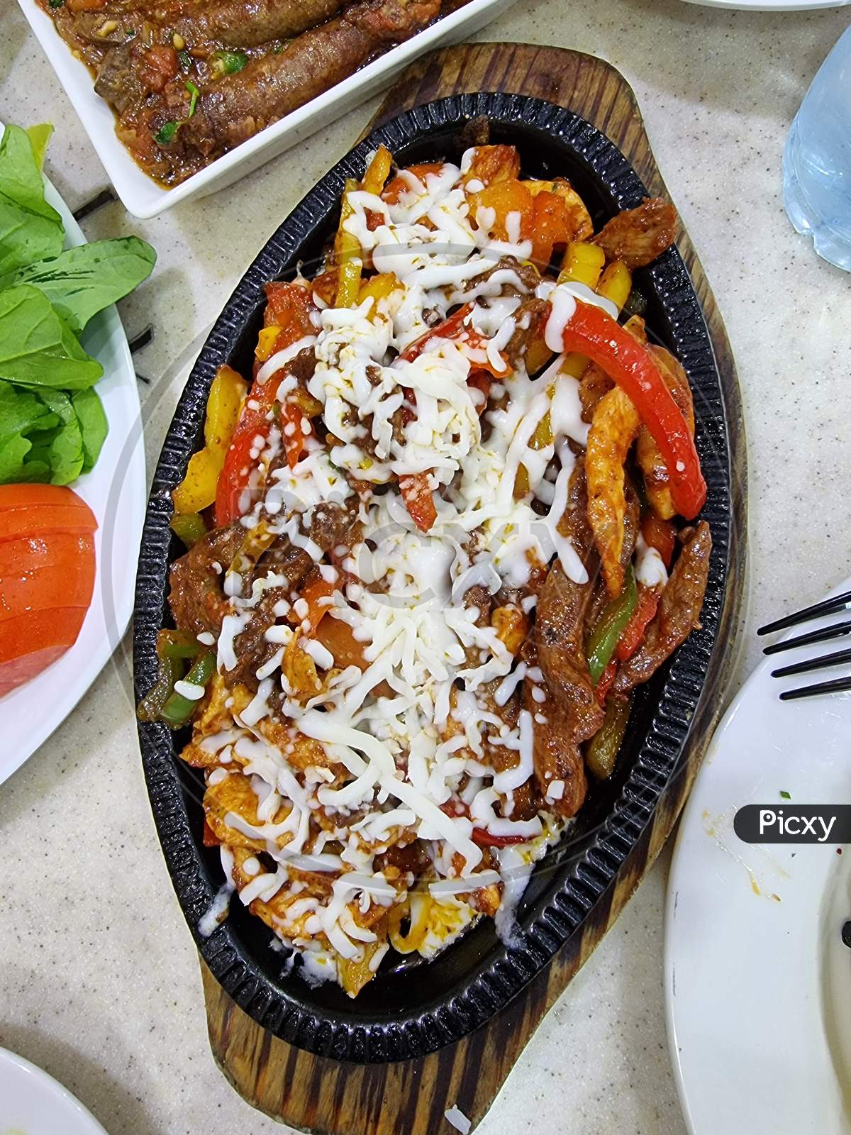 A fajita, in Tex-Mex cuisine, is any stripped grilled meat with stripped peppers and onions that is usually served on a flour or corn tortilla