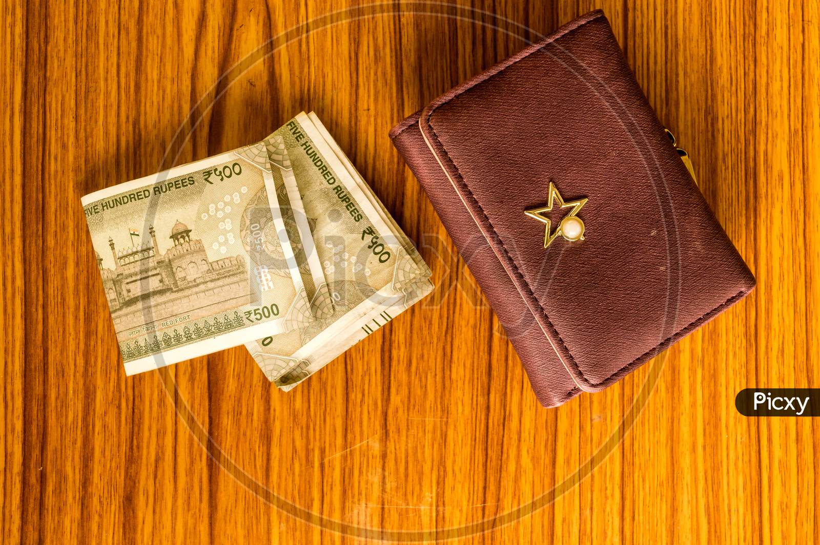 Indian Five Hundred (500) Rupee Cash Note In Brown Color Wallet Leather Purse On A Wooden Table. Business Finance Economy Concept. High Angel View With Copy Space Room For Text On Bottom Side Of Image