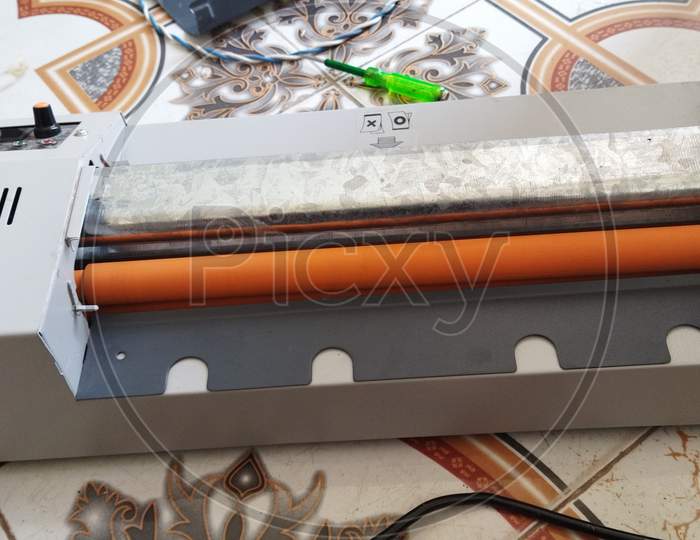 Top view of a lamination machine. Orange colour rollers fitted in the machine