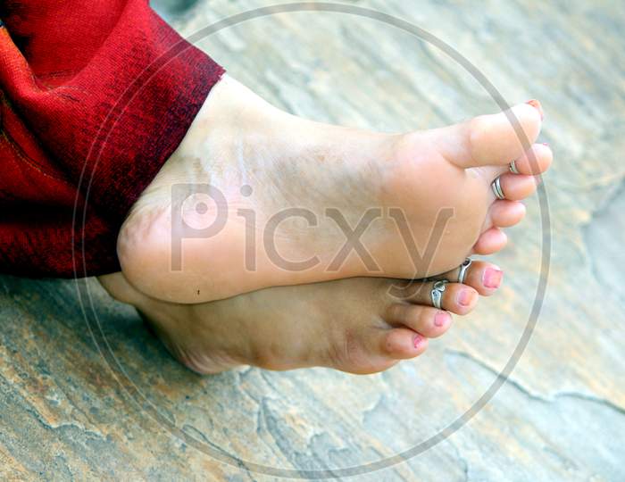 Perfect clean female feet . Beautiful and elegant groomed girl's hand touching her foot . Spa ,scrub and foot care