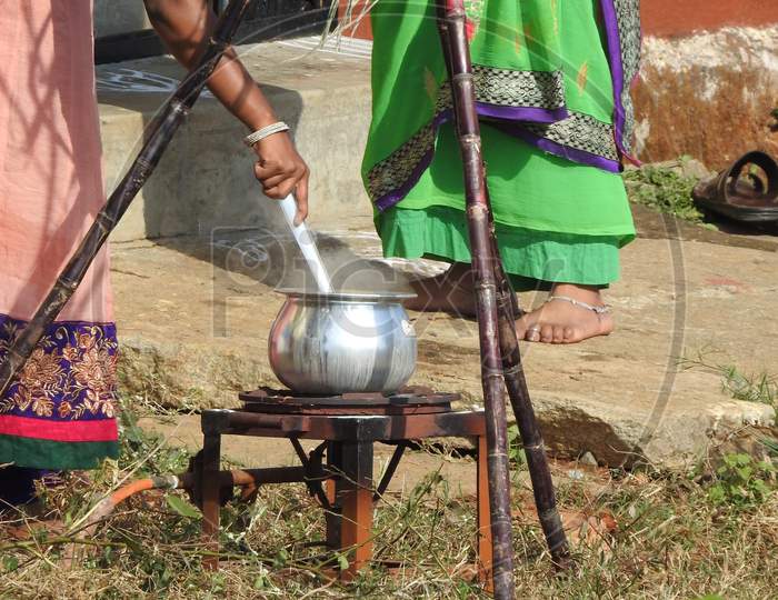 Closeup Of Indian Cute Family Celebrating Makara Sankranti Festival And Making Of Pongal Outside The House.