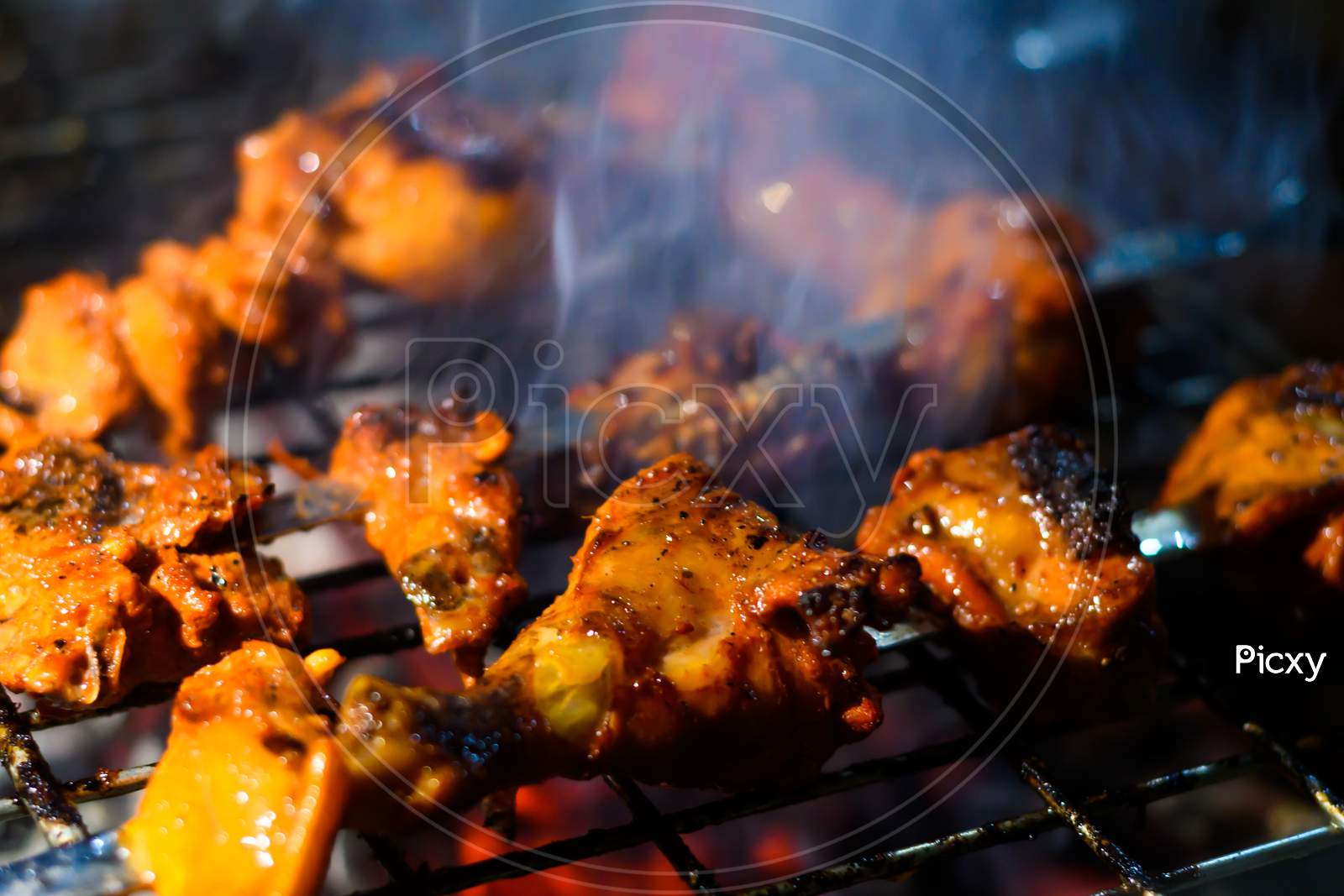 Delicious Grilled Tandoori Of Assorted Meats Over Charcoal And Hot Grill On Skewers