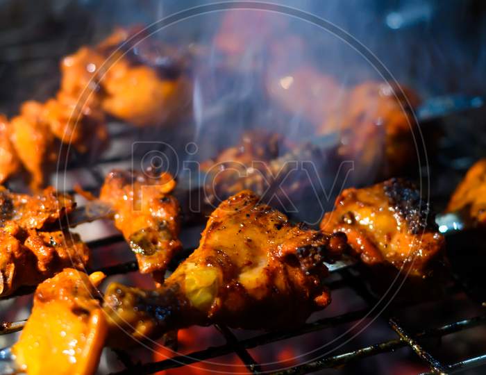 Delicious Grilled Tandoori Of Assorted Meats Over Charcoal And Hot Grill On Skewers