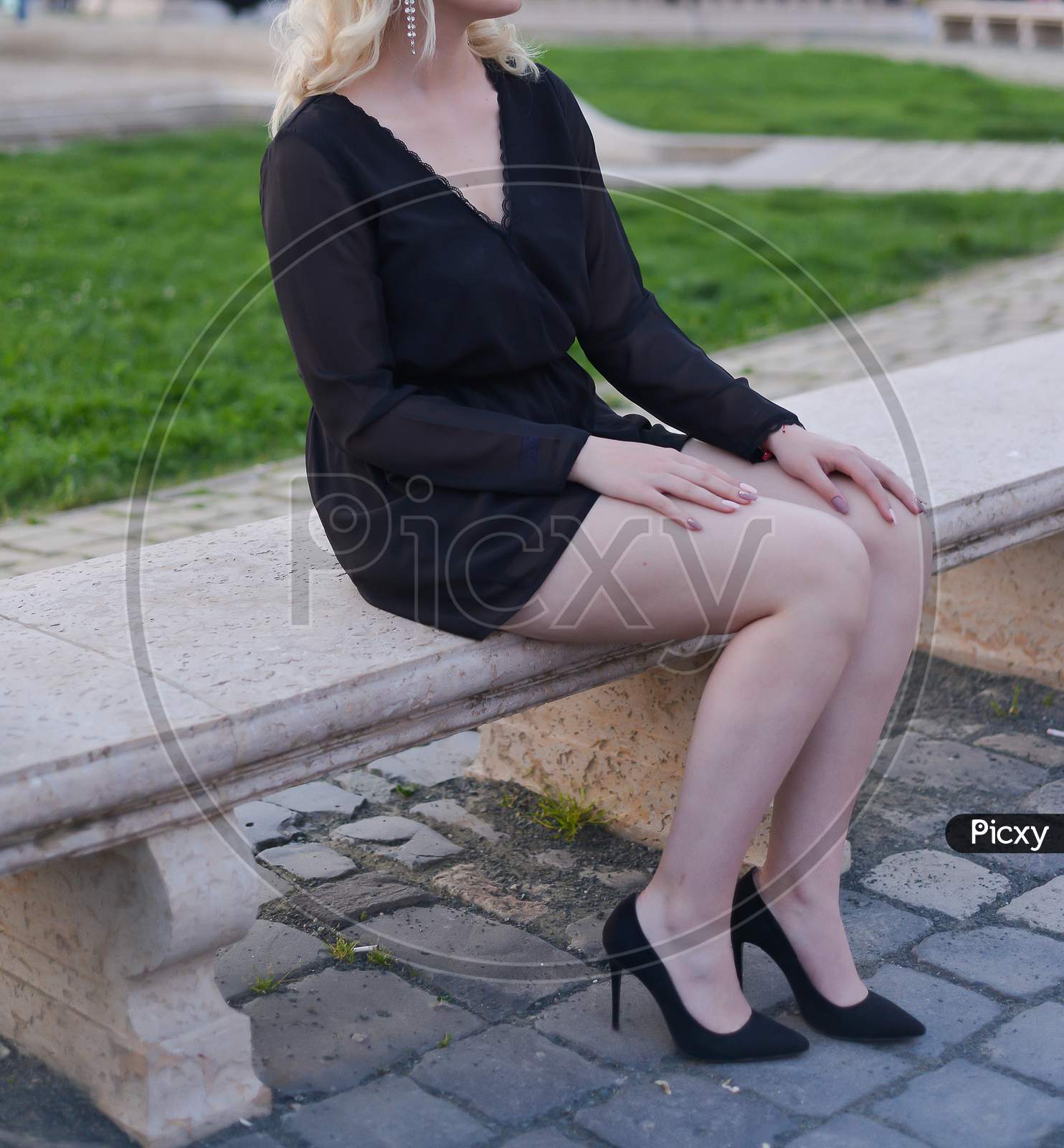 beautiful blonde model wearing a short black dress and high heels is having  a photo shooting on the street 17688722 Stock Photo at Vecteezy