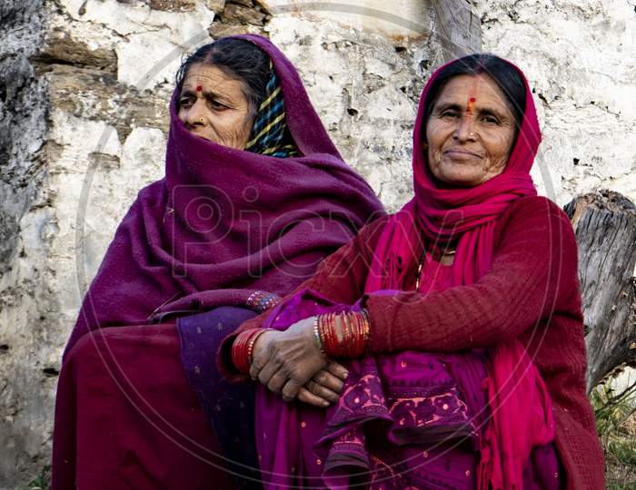 Almora, Uttarakhand - January 3 2022- Two Indian Elderly Aged Women Sitting On The Road And Looking Into The Camera. Indian Traditional Women Wearing Indian Clothes.