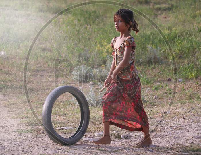 Jaipur, RaBeautiful Portrait Of A Young  Village Girl Playing With A Rubber Tyre.