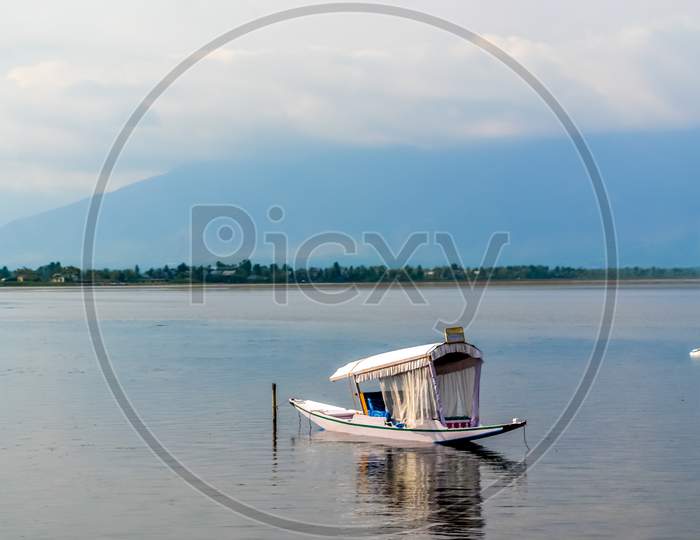 A House Boat Or Shikara Boat Ride On Dal Lake Srinagar, Jammu And Kashmir, India. The Great Himalayas Range Are Visible At A Distance. Image Taken In Romantic Sunset Time.