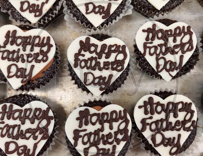 Happy Fathers Day Writing On White Colour Heart Shaped Chocolate Decoration On Top Of A Cupcake