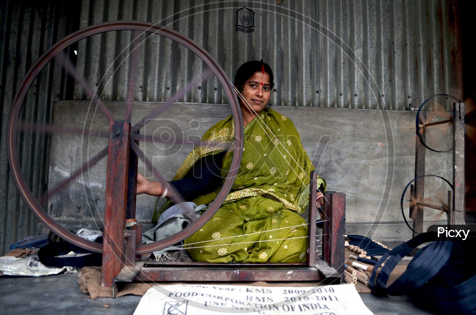 Image of aWoman spinning thread to weave saree-QP569113-Picxy