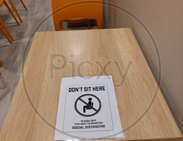 Do Not Sit Sign On A Table Due To Covid-19 To Ensure Social Distancing