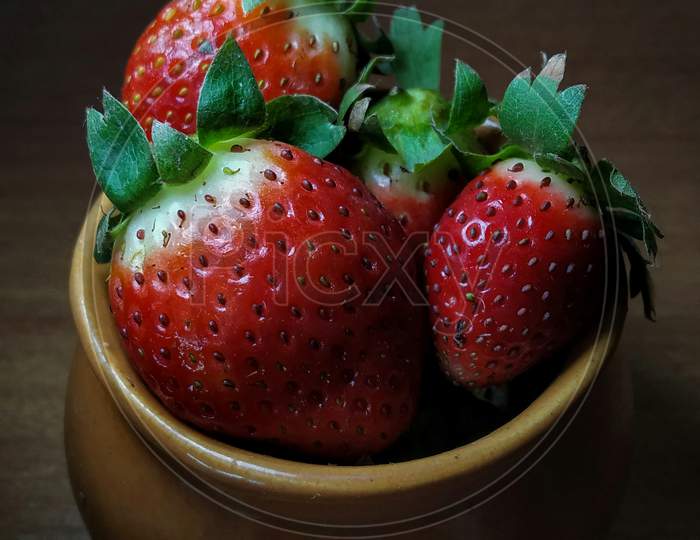 Fresh strawberries in clay pot